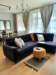 a living room with a blue couch and a table at Apartament Amber Dwie Sypialnie Stare Miasto in Elblag