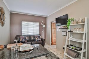 a living room with a couch and a table at Rudman Townhouses - OR Tambo Airport in Boksburg
