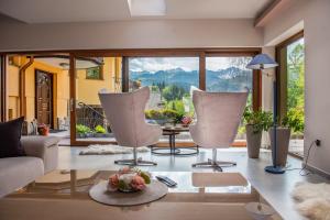 a living room with two chairs and a table at Willa Alesandro in Zakopane