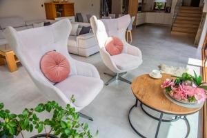 un soggiorno con 2 sedie bianche e un tavolo di Willa Alesandro a Zakopane