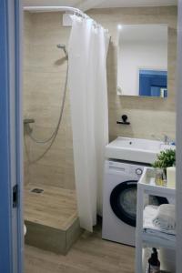 y baño con ducha y lavadora. en Naujai suremontuotas butas miesto centre., en Visaginas