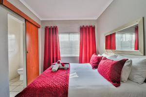 a bedroom with a bed with a teddy bear on it at Rudman Townhouses - OR Tambo Airport in Boksburg