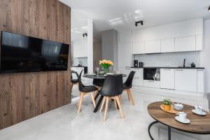 a kitchen and dining room with a table and chairs at Sun Towers Lux Apartments by Renters Prestige in Świnoujście
