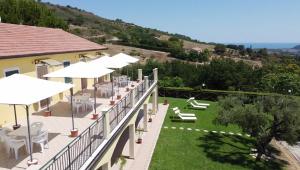 a balcony with white chairs and umbrellas on a building at Agriturismo Monte Maggio in Lapedona