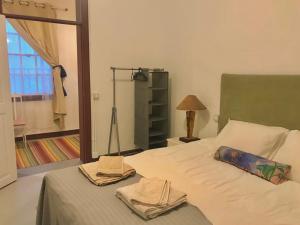 um quarto com uma cama com toalhas e uma janela em Casa VivaQi Tenerife em Granadilla de Abona