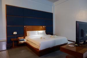 um quarto com uma cama grande e uma televisão em The Park - Silang em Silang