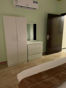1 dormitorio con 1 cama, vestidor y armario en شقق مفروشه خاصه بالطائف, en Taif