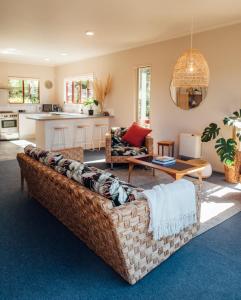 a living room with a couch and a table at Kakariki by the sea in Ngunguru