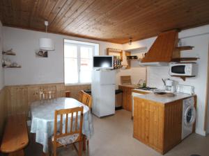 a kitchen with a table and a white refrigerator at Appartement Lanslebourg-Mont-Cenis, 3 pièces, 5 personnes - FR-1-508-253 in Lanslebourg-Mont-Cenis