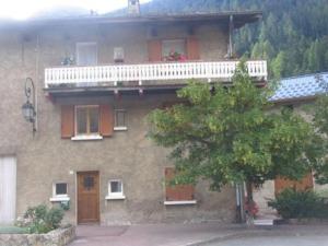 a building with a balcony and a tree in front of it at Appartement Lanslebourg-Mont-Cenis, 3 pièces, 5 personnes - FR-1-508-253 in Lanslebourg-Mont-Cenis