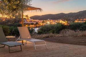 2 sillas y una sombrilla en una terraza con vistas en Finca Contrabando completa 20 pax, en Huelva