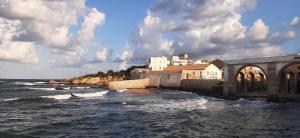 a group of buildings on a hill next to the ocean at Concas Apartaments in Portoscuso