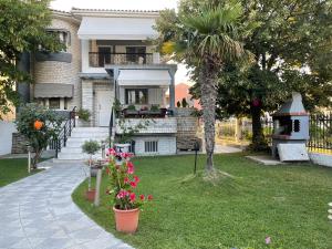 ein Haus mit einem Garten mit Blumen im Hof in der Unterkunft Nikiti Palataki in Nikiti