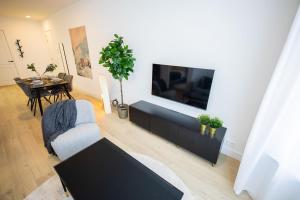 uma sala de estar com uma televisão de ecrã plano na parede em Admiringly 1 Bedroom Serviced Apartment 56m2 -NB306A- em Roterdã
