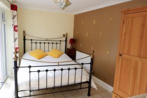 a bedroom with a bed with yellow pillows on it at Colchester Sunny Studio Apartment with EV Charging Point in Lexden