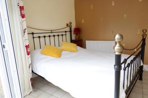 um quarto com uma cama com almofadas amarelas em Colchester Sunny Studio Apartment with EV Charging Point em Lexden