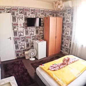 ニーレジハーザにあるJocó Panzióのベッドルーム1室(ベッド1台付)が備わります。壁紙を用いた内装です。