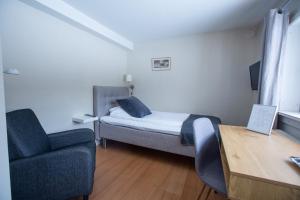 ein kleines Zimmer mit einem Bett und einem Stuhl in der Unterkunft Hotell Strandvillan B&B in Orsa