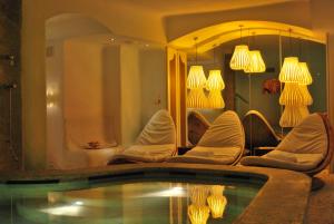 a room with chairs and a swimming pool with lights at Grand Hotel Savoia in Genoa