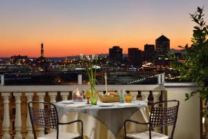 a table on a balcony with a view of the city at Grand Hotel Savoia in Genoa