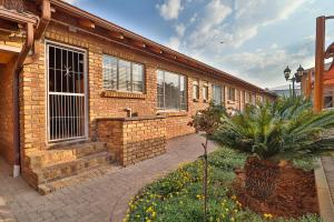 a brick building with windows and a courtyard at Rudman Townhouses Self-catering Accommodation in Boksburg