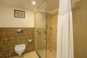 a bathroom with a toilet and a glass shower at Sterling Mussoorie in Mussoorie