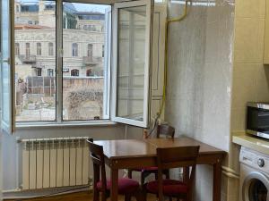 a kitchen with a table and two chairs and a window at Mayden Family Apartment in Baku