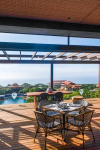 um pátio com uma mesa e cadeiras num deque em The Capital Zimbali em Ballito