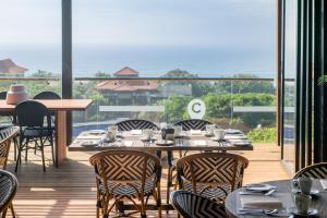 a restaurant with a table and chairs and a balcony at The Capital Zimbali in Ballito