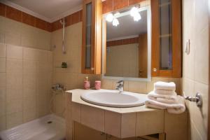 a bathroom with a sink and a mirror and a tub at Luxury Traditional Villa in Khiliódhendron