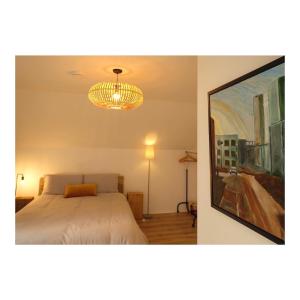 1 dormitorio con cama y lámpara de araña en Dromdiah Lodge en Killeagh