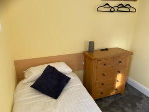 a small bedroom with a bed and a wooden dresser at The Beach Side in Redcar
