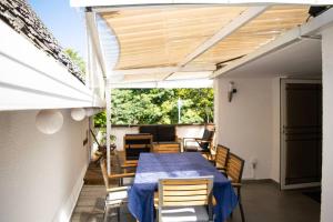 a table and chairs on a patio with a roof at Le Flamboyant in Saint-Gilles les Bains