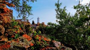 a building with a clock tower in the distance at Charme de Monsaraz in Monsaraz