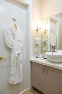 a bathroom with a white robe hanging next to a sink at Hotel FN Shymkent in Shymkent