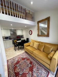 a living room with a couch and a kitchen at The old coach house 8 North lane in Kent