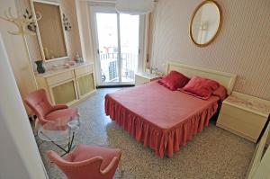 um quarto com uma cama, 2 cadeiras e um espelho em LETS HOLIDAYS Apartment for 6 people 1 min walking to the beach em Tossa de Mar
