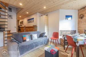 ein Wohnzimmer mit einem Sofa und einem Tisch in der Unterkunft Roc de Burel in Lanslevillard