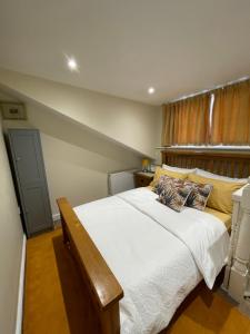 sypialnia z dużym łóżkiem z białą pościelą i poduszkami w obiekcie The old coach house 8 North lane w mieście Kent