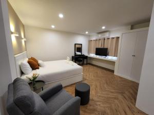 Habitación de hotel con cama y sofá en HOMMORY RESIDENCE - Chalong West en Ban Klang