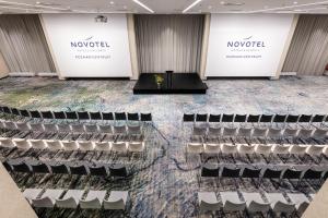 a stage in a room with chairs and signs at Novotel Poznan Centrum in Poznań