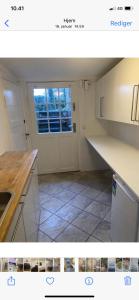 a kitchen with white cabinets and a window at Hellerup - suite 1 in Hellerup