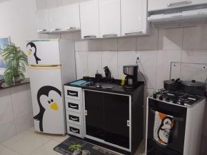 een keuken met een fornuis en een pinguïnkoelkast bij Doce Lar in Cabo Frio