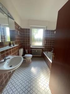 baño con lavabo y aseo y ventana en Ferien & Monteurwohnung in Bohmte-Hunteburg, en Bohmte