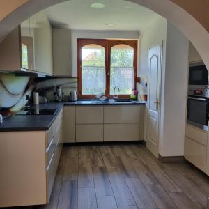 an arched kitchen with a sink and a counter top at Holiday Vendégház in Siófok
