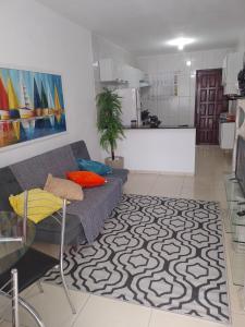 uma sala de estar com um sofá e uma cozinha em Doce Lar em Cabo Frio