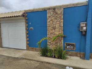 due porte blu del garage su un edificio con un muro di pietra di Doce Lar a Cabo Frio