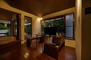 a living room with a desk and a chair and windows at Private Villas Ryuz備瀬 in Motobu +40 photos
