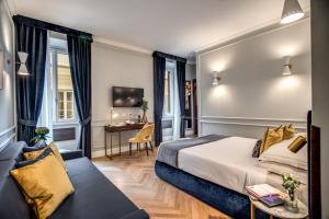 um quarto de hotel com uma cama e uma secretária em Tree Charme Augusto Luxury Suites em Roma