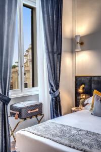 1 dormitorio con cama y ventana en Tree Charme Augusto Luxury Suites en Roma